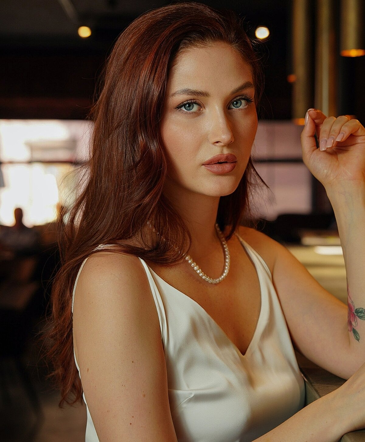 Woman relaxing by a pool, serene expression.